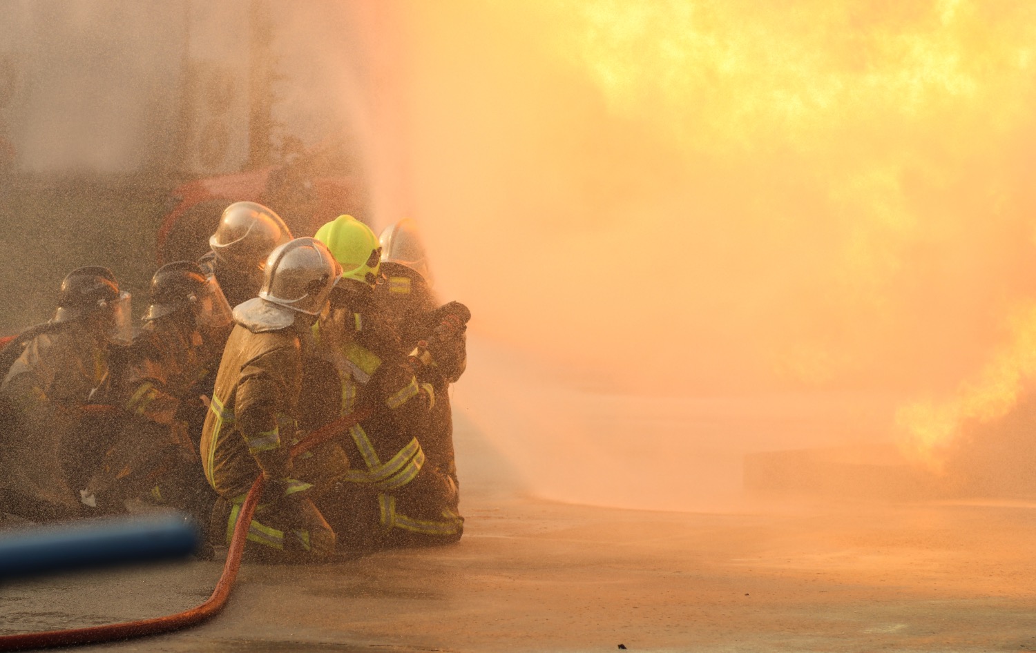 firefighters using twirl water fog type fire extinguisher fighting with fire flame from oil control fire spreading out firefighter industrial safety concept